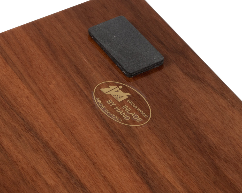 Close-up of wooden chess board with "Made by Hand in Italy" label and felt pad