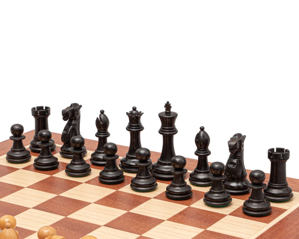The Warwick Series 3 inch Ebonised Staunton Chessmen displayed on a chessboard with beautifully carved boxwood pieces.